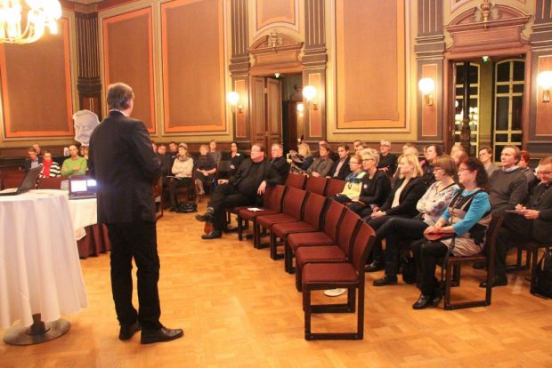 Raatihuoneen yleisö kuuntelemassa Hämeen Yrittäjien toimitusjohtaja Juha Haukan esitystä.